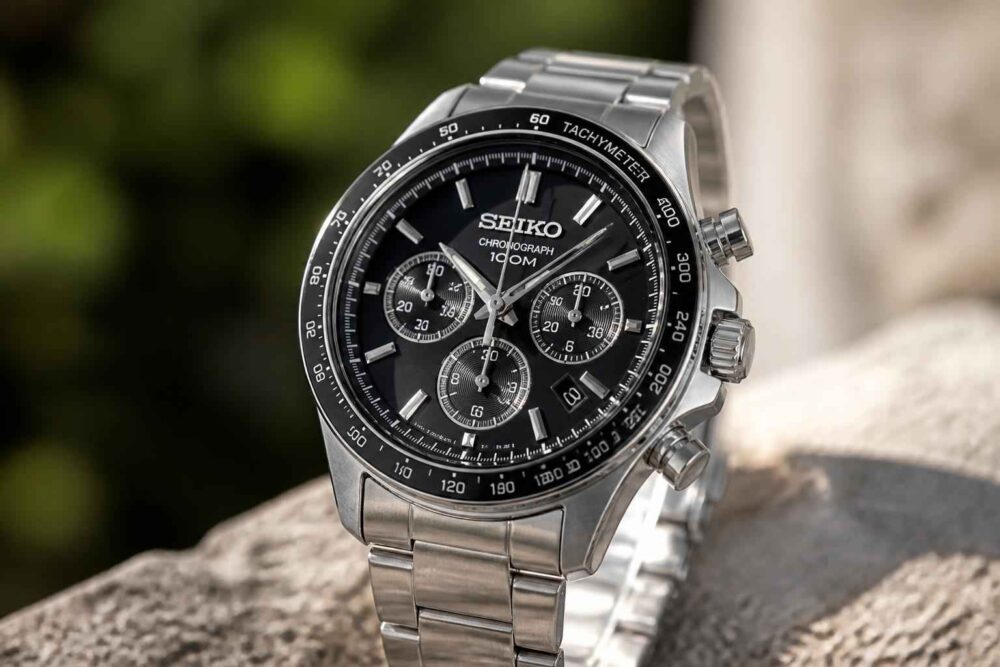 Srebrny chronograf Seiko z czarną tarczą oparty na kamieniu w plenerze